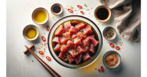 Mixing bowl on a white surface with ahi tuna being mixed with sesame oil, soy sauce, and chili flakes